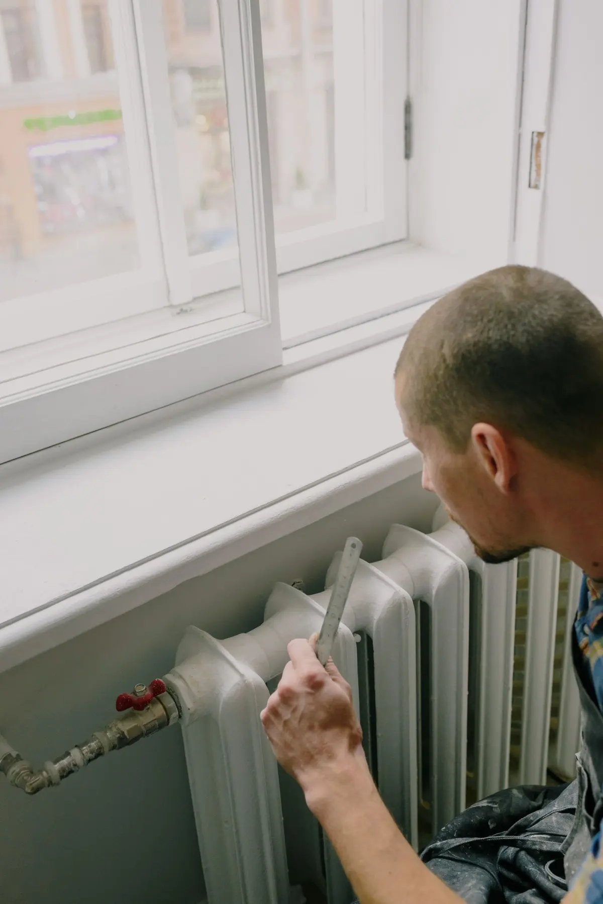 Chauffagiste intervenant sur un radiateur